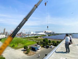 クレーンを使用してシャワー室の部材搬入